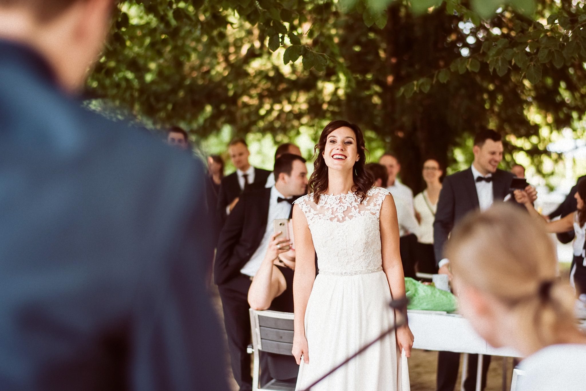Lachende Braut inmitten ihrer Hochzeitsgäste