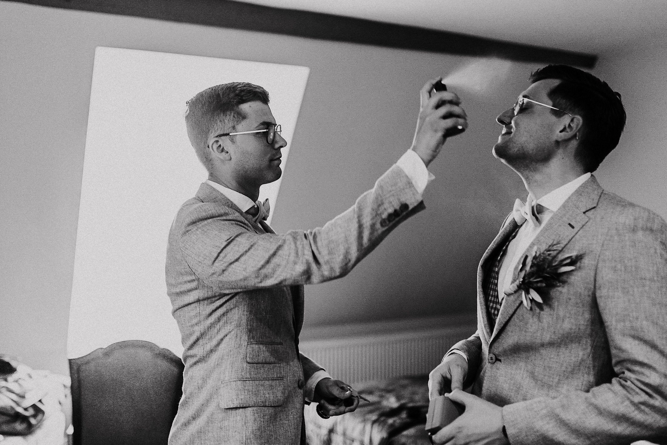 Bräutigam besprüht seinen Mann mit Parfüm bei der Hochzeit in Großkarlbach