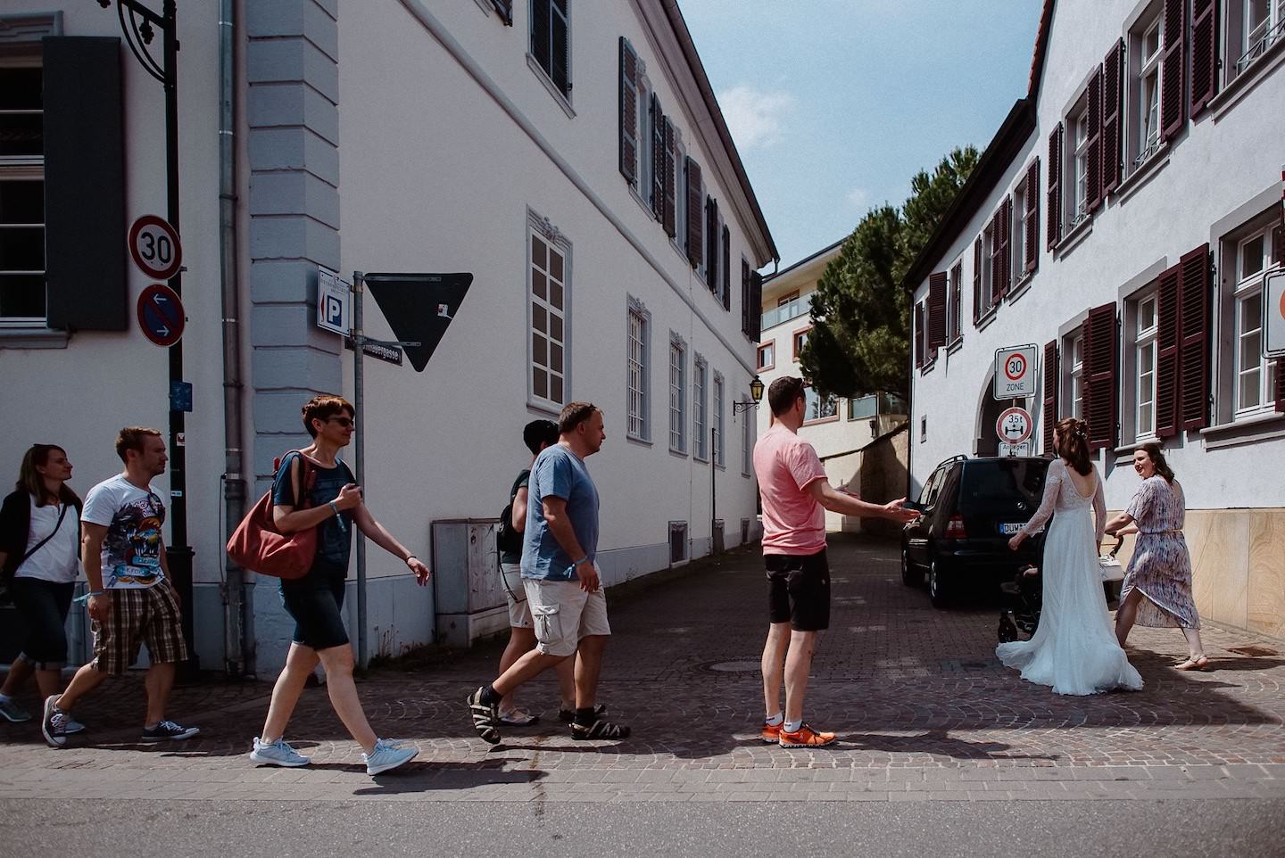 Touristen in Deidesheim entdecken die Braut auf dem Weg zur Kirche