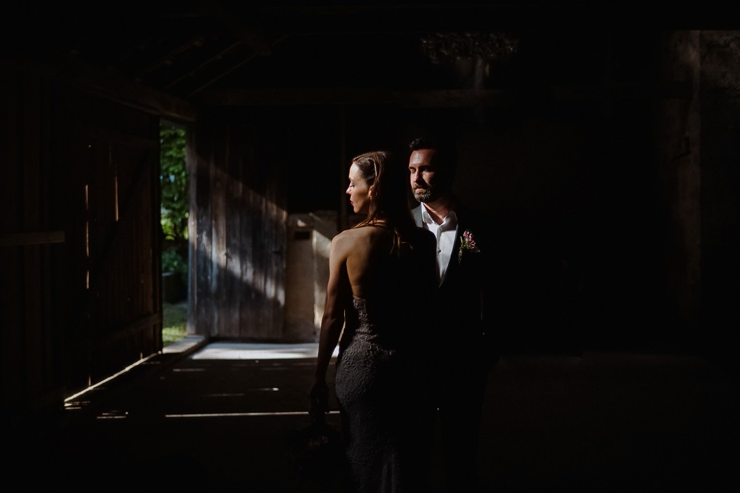 Hochzeitsfotograf im Berthold 57, Hochzeitsportrait in der Scheune in 57 Kraichtal - das Brautpaar steht in einem Strahl aus Licht