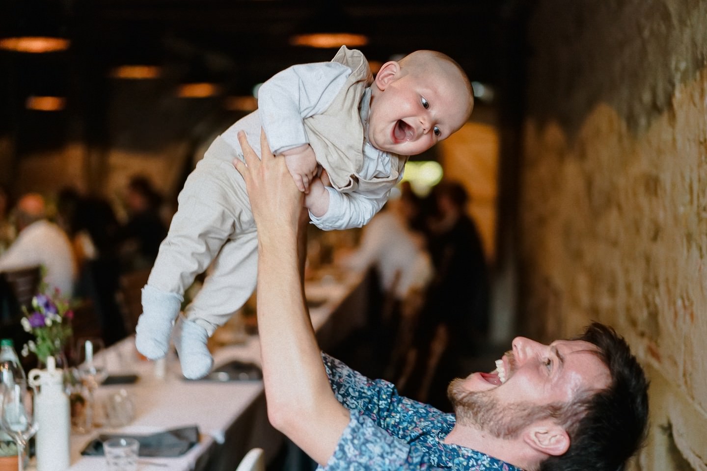 Baby freut sich weil sein Vater es durch die Luft wirft