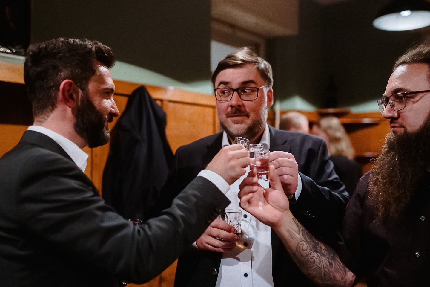 Gäste auf der Hochzeit trinken Schnaps mit dem Bräutigam