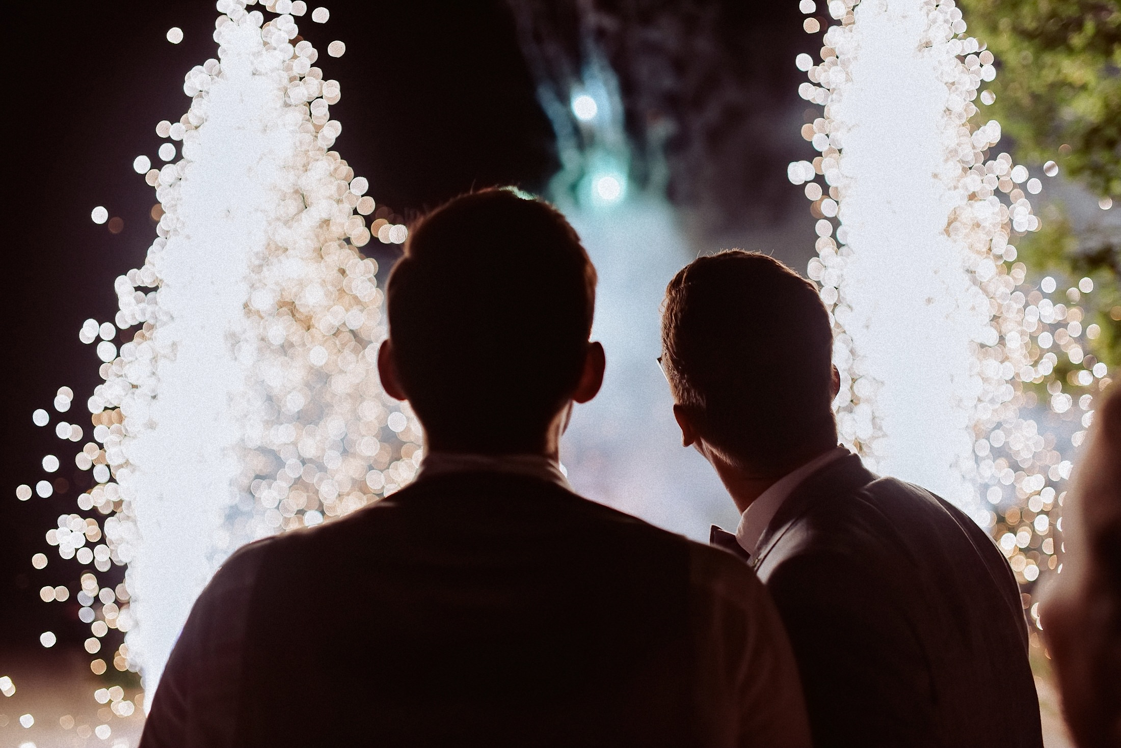 zwei Bräutigame betrachten das Feuerwerk zu ihrer gleichgeschlechtlichen Hochzeit in der Pfalz