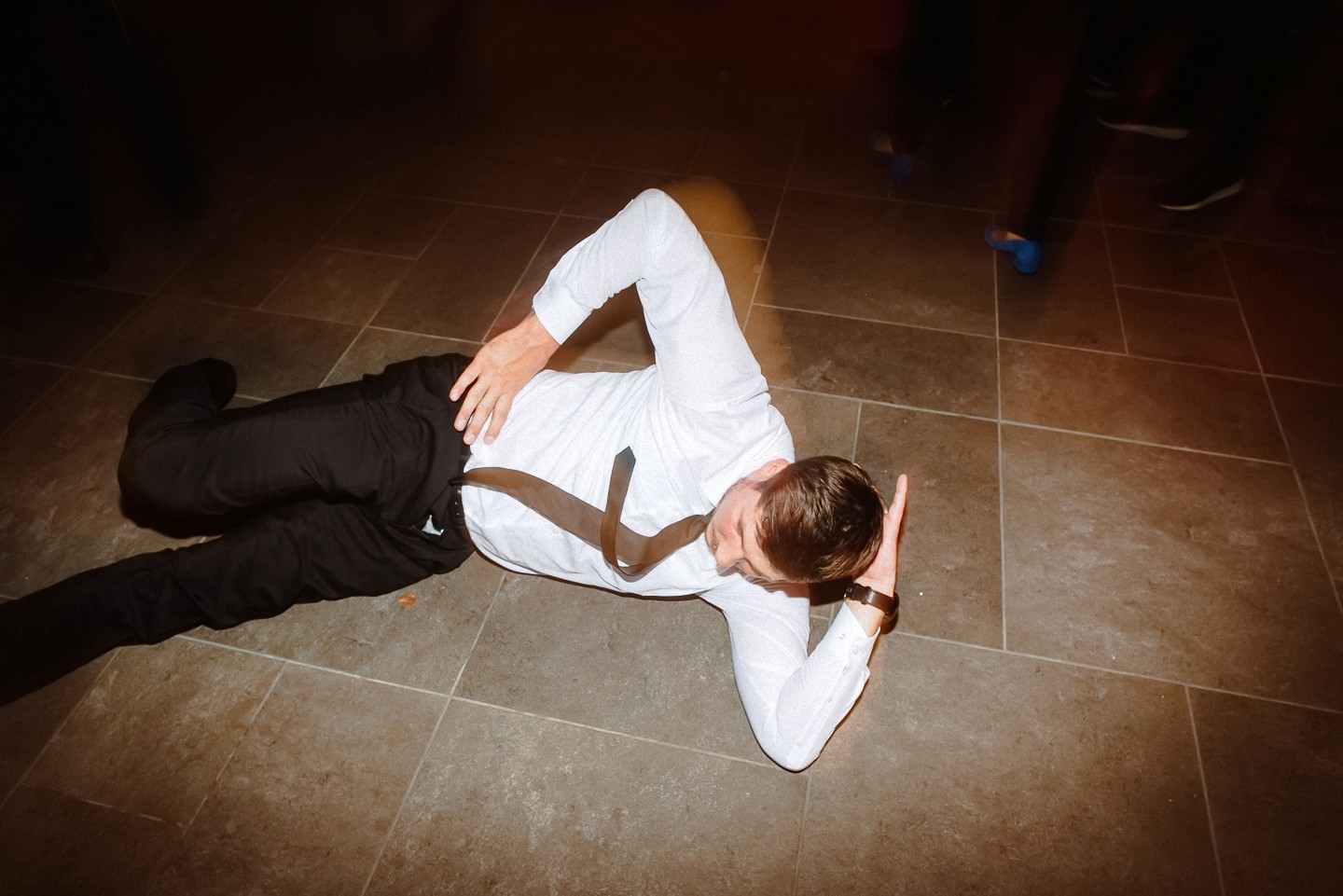 Gast tanzt auf dem Boden bei der Hochzeitsparty