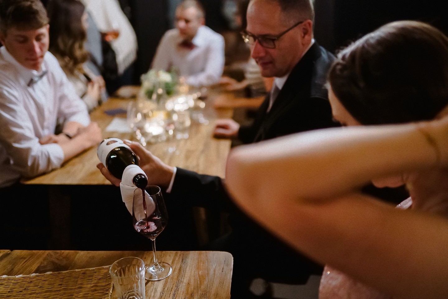 Gast schenkt Wein ein bei der Hochzeitsreportage im Speicher 7