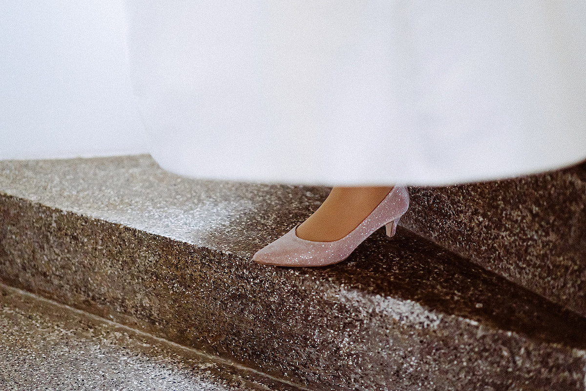 Glitzernde Schuhe der Braut auf dem Weg in die Kirche