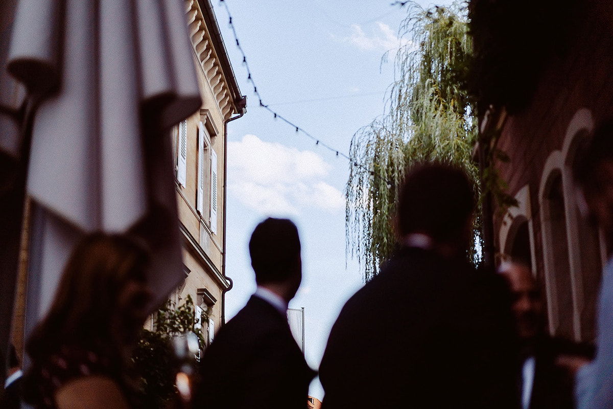 Hochzeitsgesellschaft bei von Winning unscharf im Vordergrund, man sieht den Himmel im Hintergrund