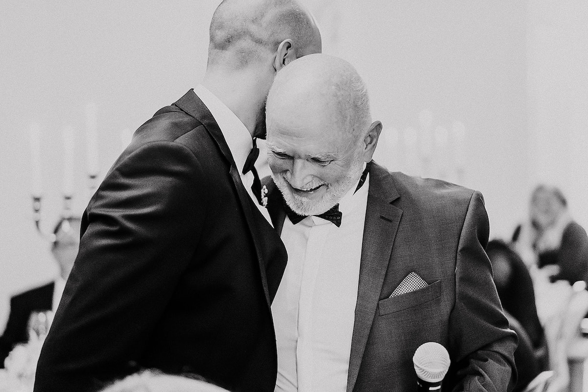 Vater umarmt seinen Sohn auf dessen Hochzeit im Weingut von Winning