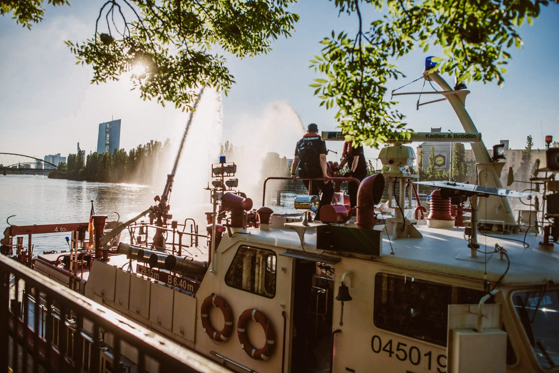 Das Feuerwehrboot mit Wasserfontänen sprüht neben der Backschaft.