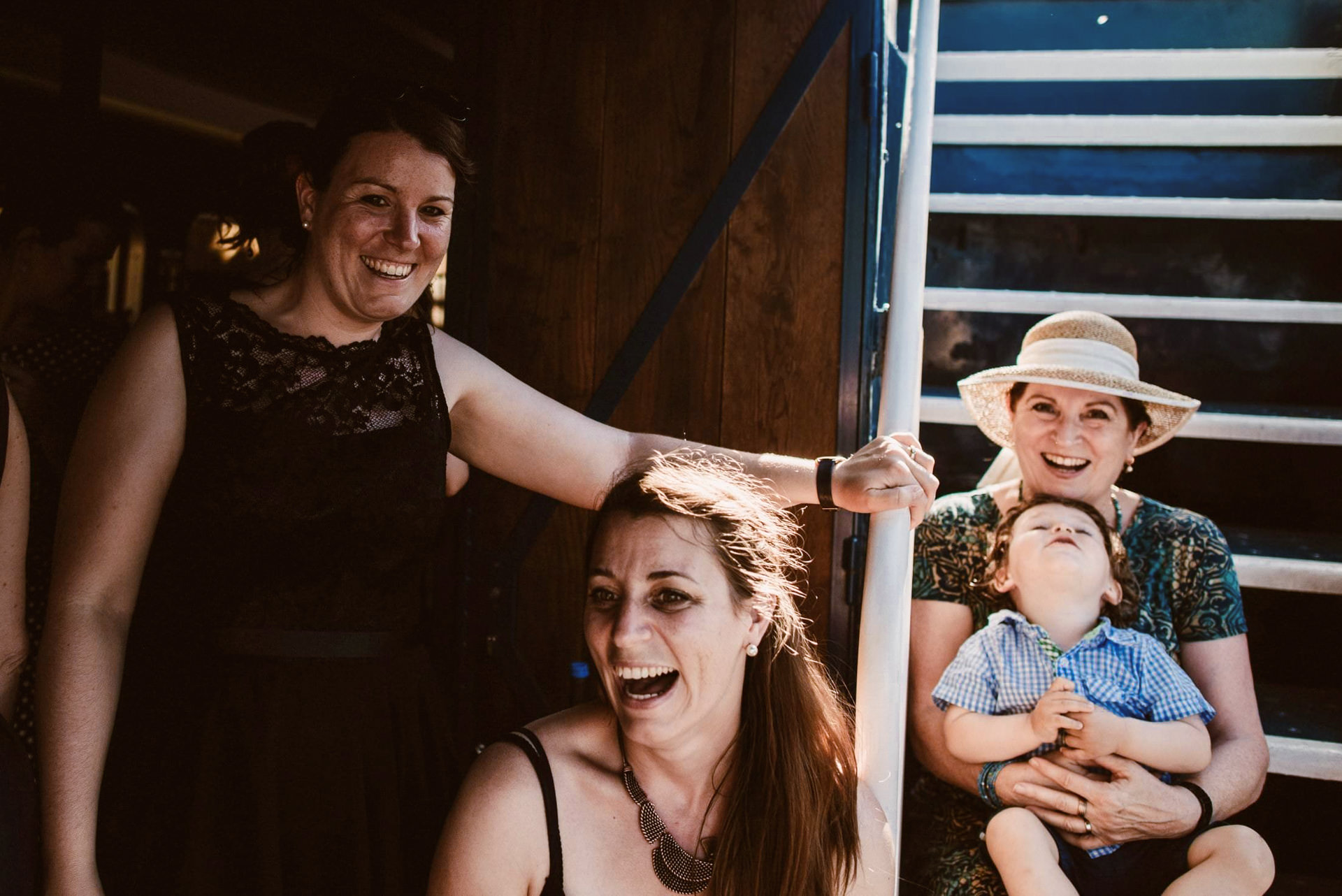 Frauen lachen fröhlich und ausgelassen im Schiff beim Hochzeitsempfang.