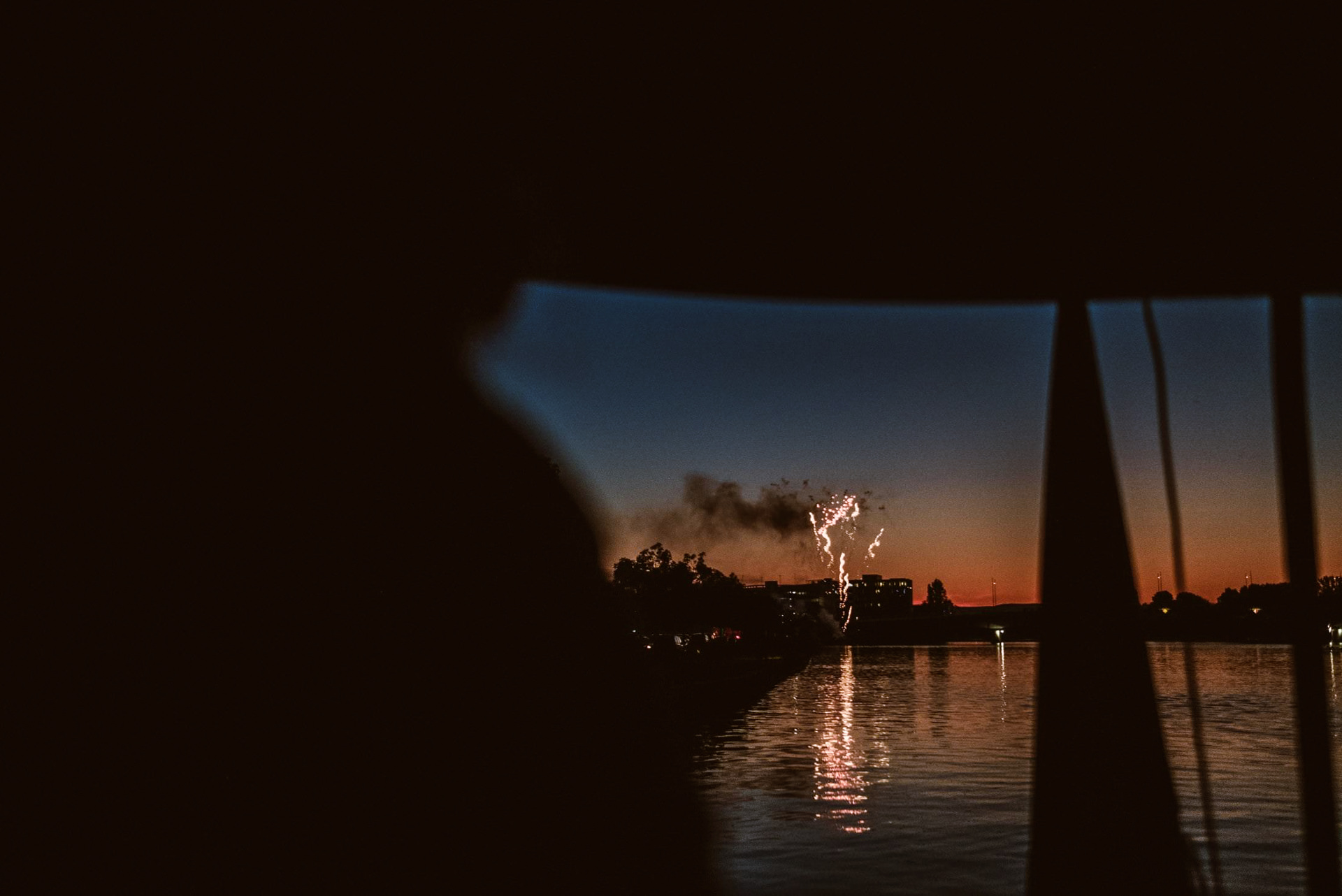 Schwarzweiß: Gäste sitzen unter Zelt und stoßen beim Feuerwerk an.