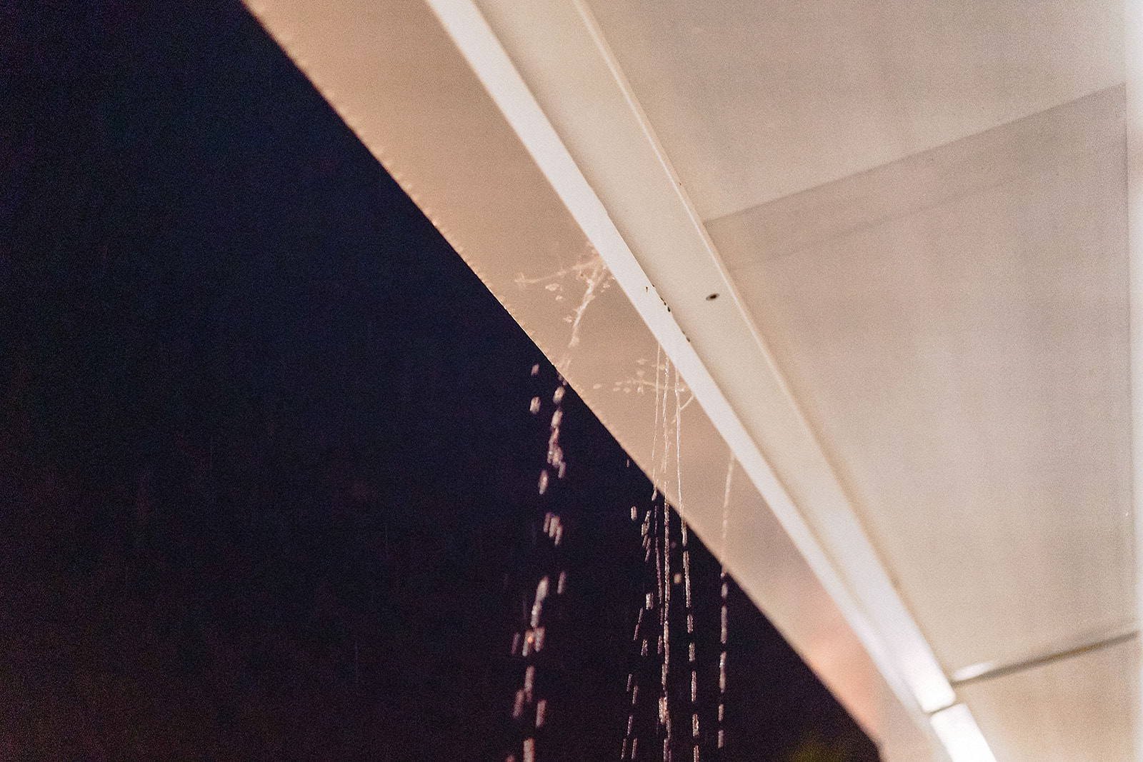 Eine Lichterkette hängt bei Nacht am Sonnensegel der Terrasse