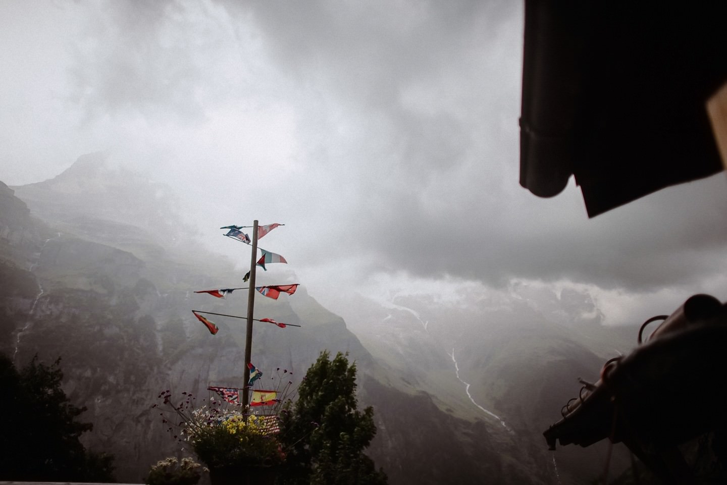 Flaggenpfahl mit wehenden Schweizer Flaggen, Berglandschaft.