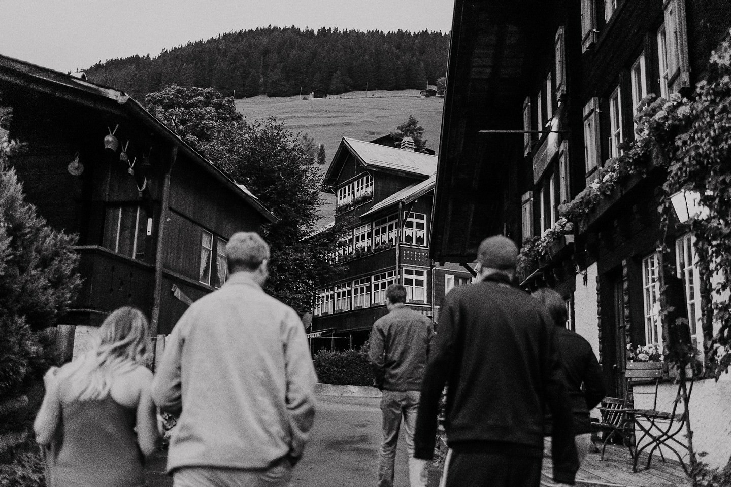 Gäste spazieren durch Gimmelwald-Dorf, Holzbauten, Schwarz-Weiß.