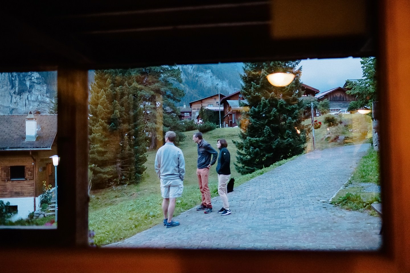 Wandergruppe verlässt Hostel abends, Berglandschaft, Abenteuer.