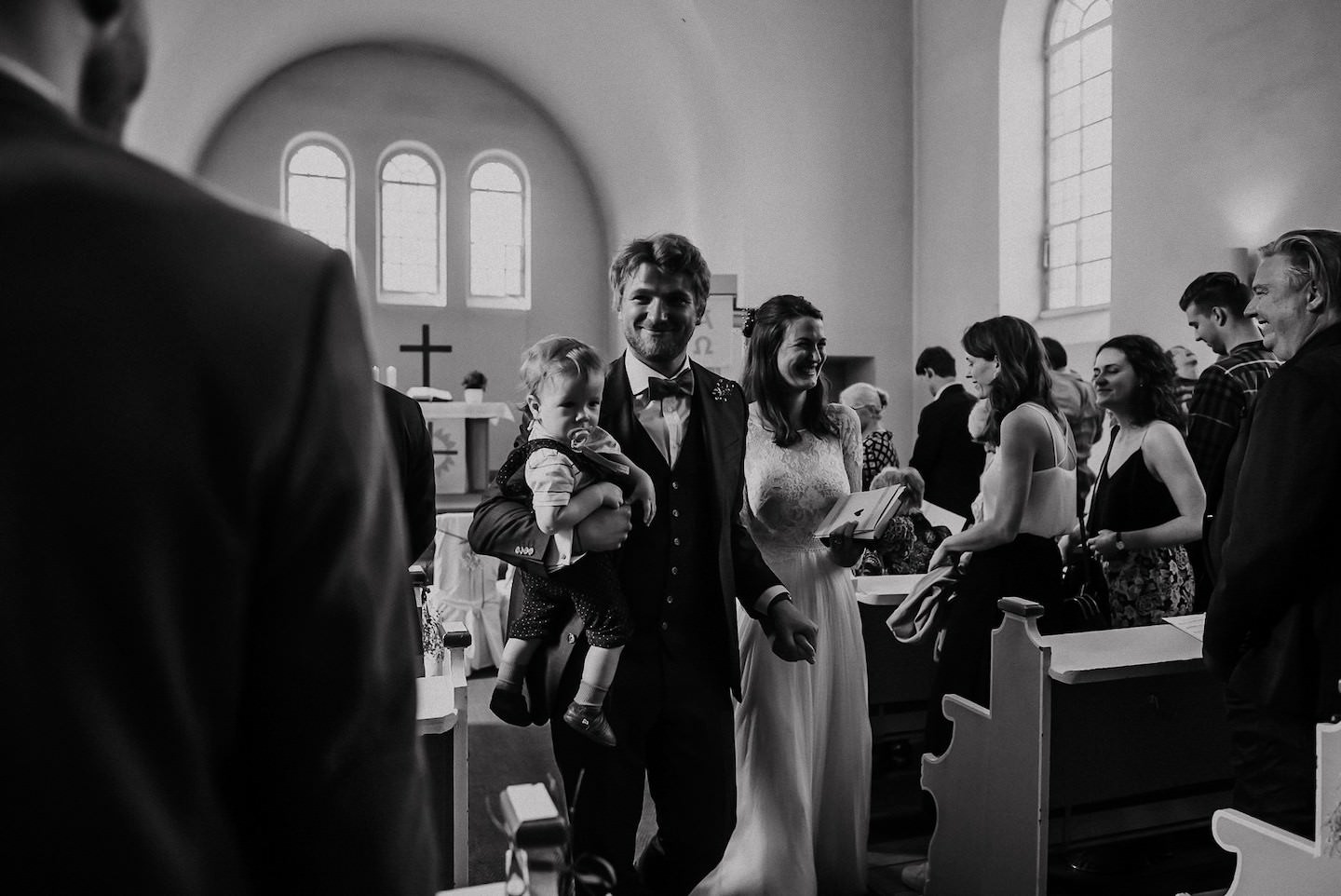Brautpaar beim Auszug aus der Kirche, schwarz-weiß, emotional geladener Moment.