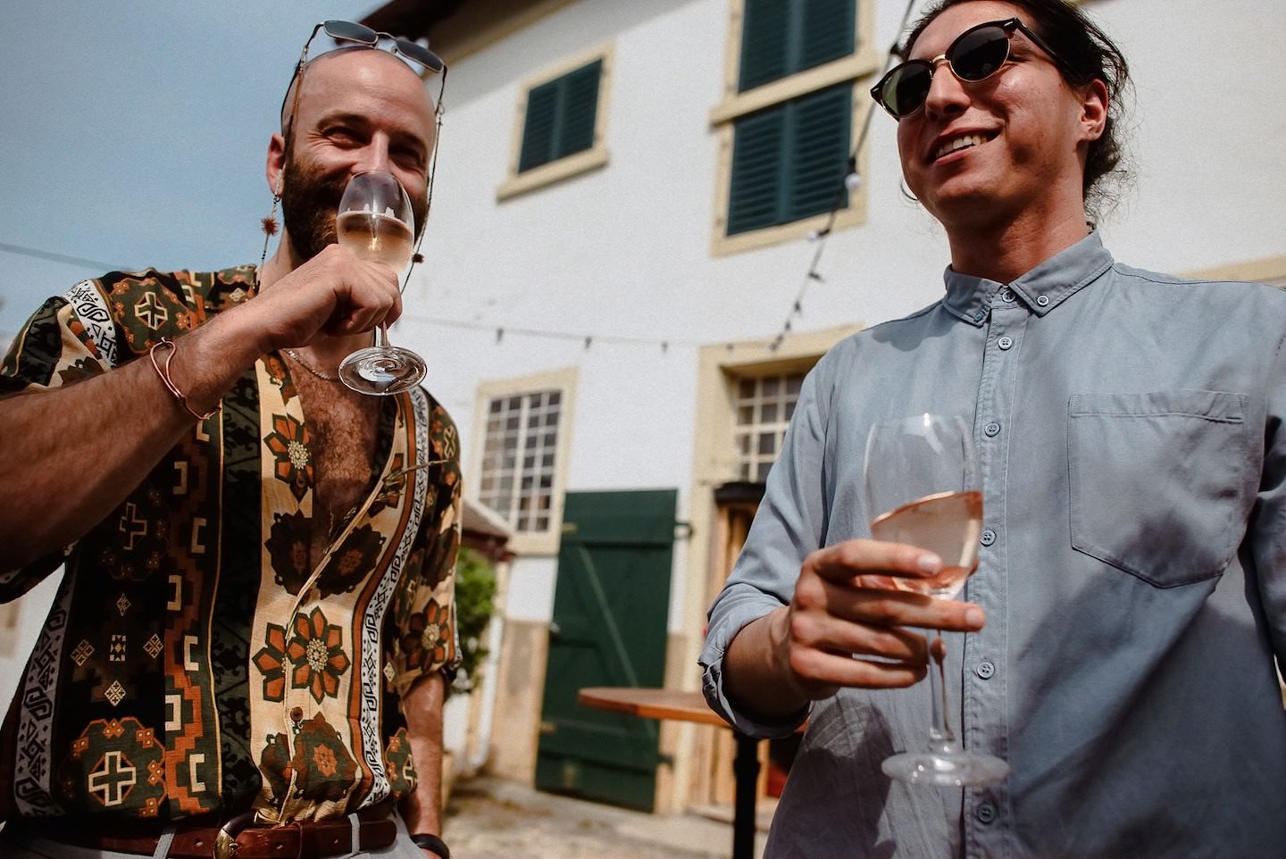 Hochzeitsgäste trinken Sekt im Hofgut während Empfang, fröhlich.