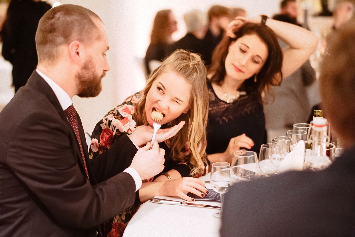 Essende Gäste beim Hochzeitsdiner in fröhlicher Runde.