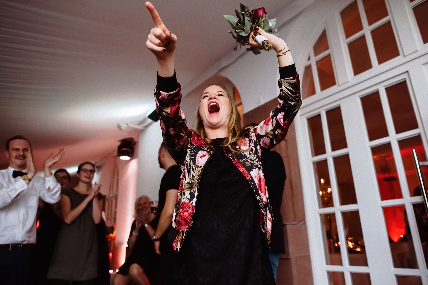 Gast fängt den Blumenstrauß nach der Hochzeit.