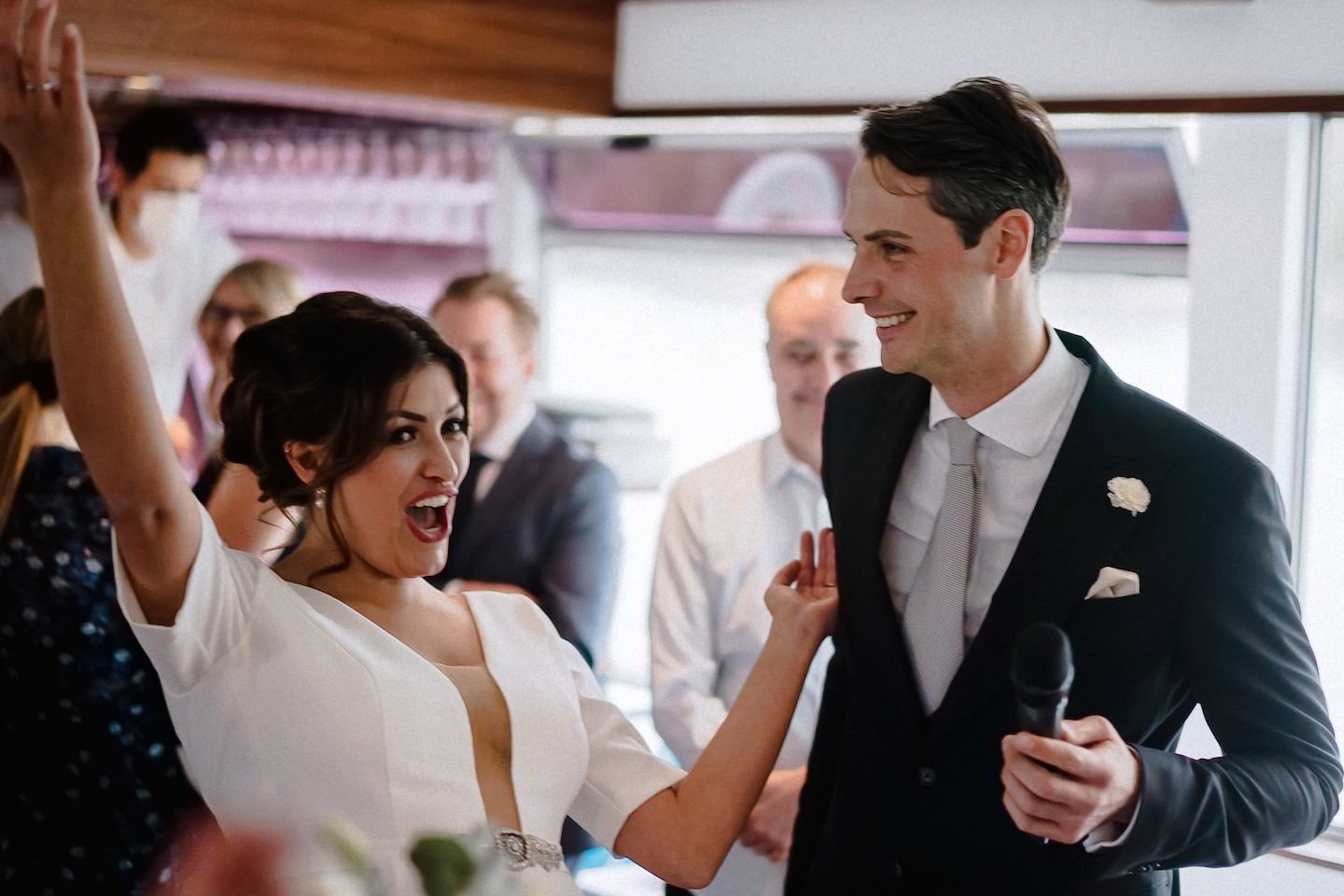 Gäste fotografieren die Hochzeitstorte und das Brautpaar an Bord