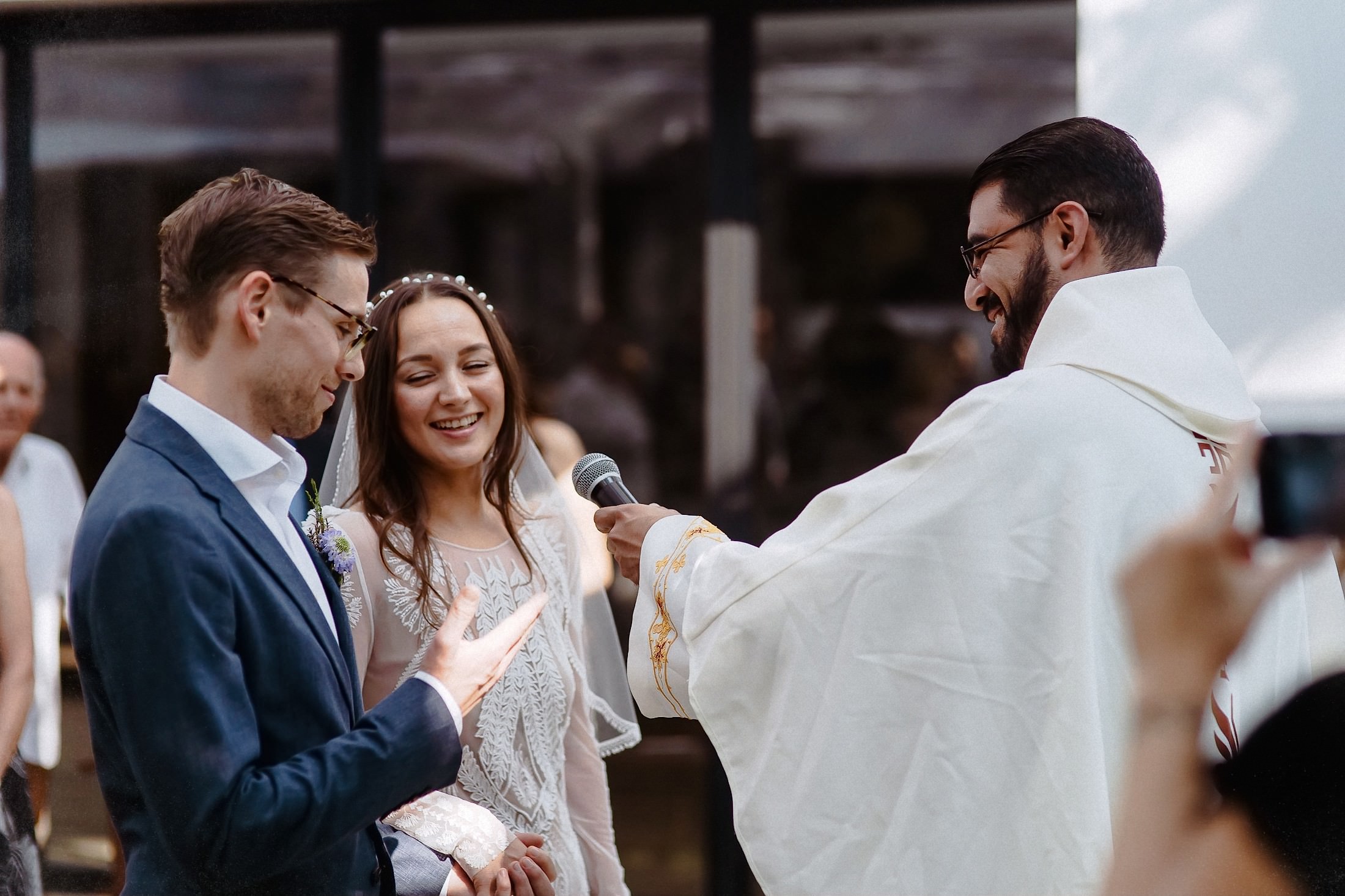Bräutigam, Braut und Priester stehen gemeinsam am Altar während der Zeremonie