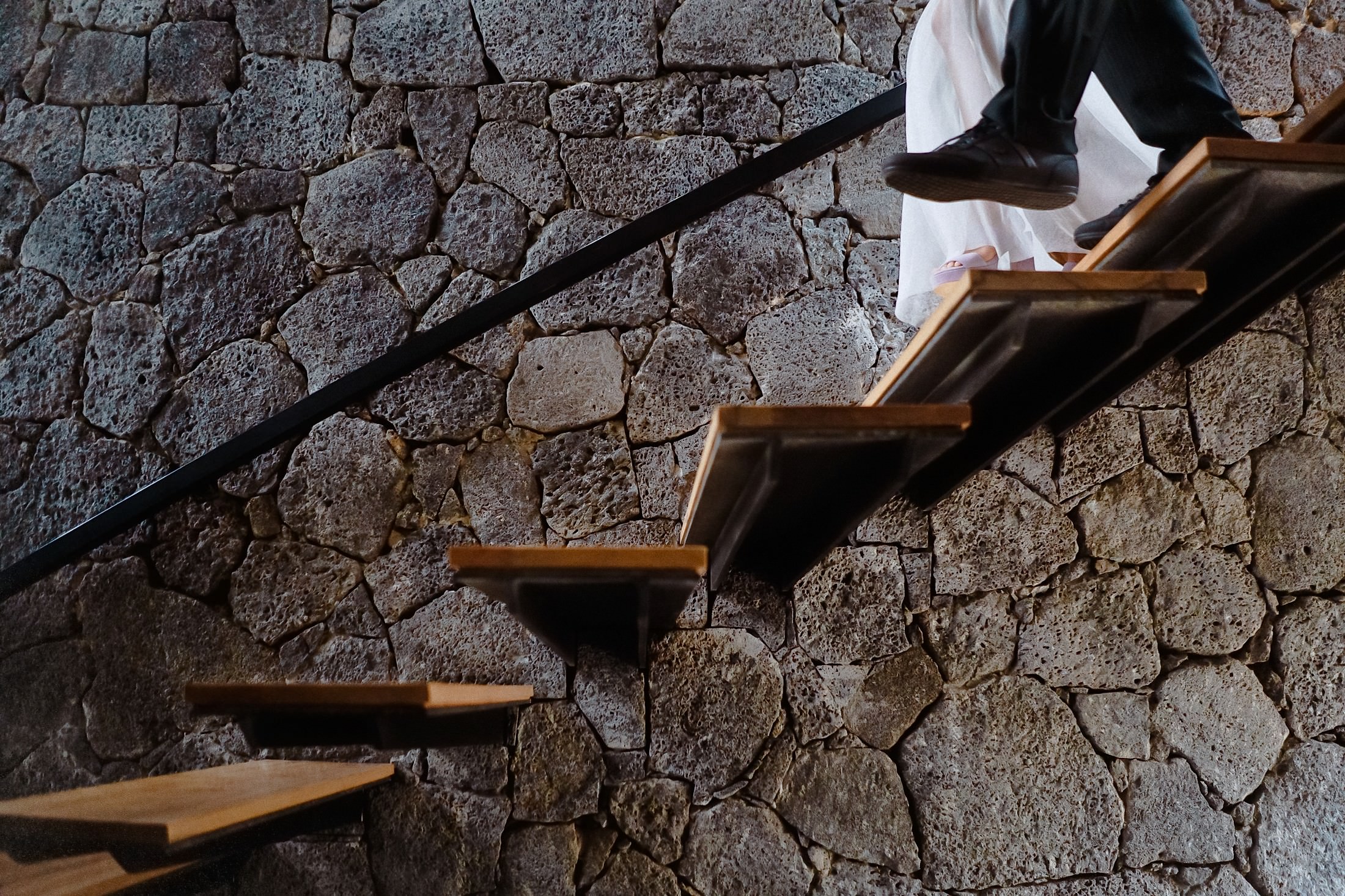 Eine Detailaufnahme zeigt die Schuhe der Braut auf der Treppe mit dem Schatten des Bräutigams