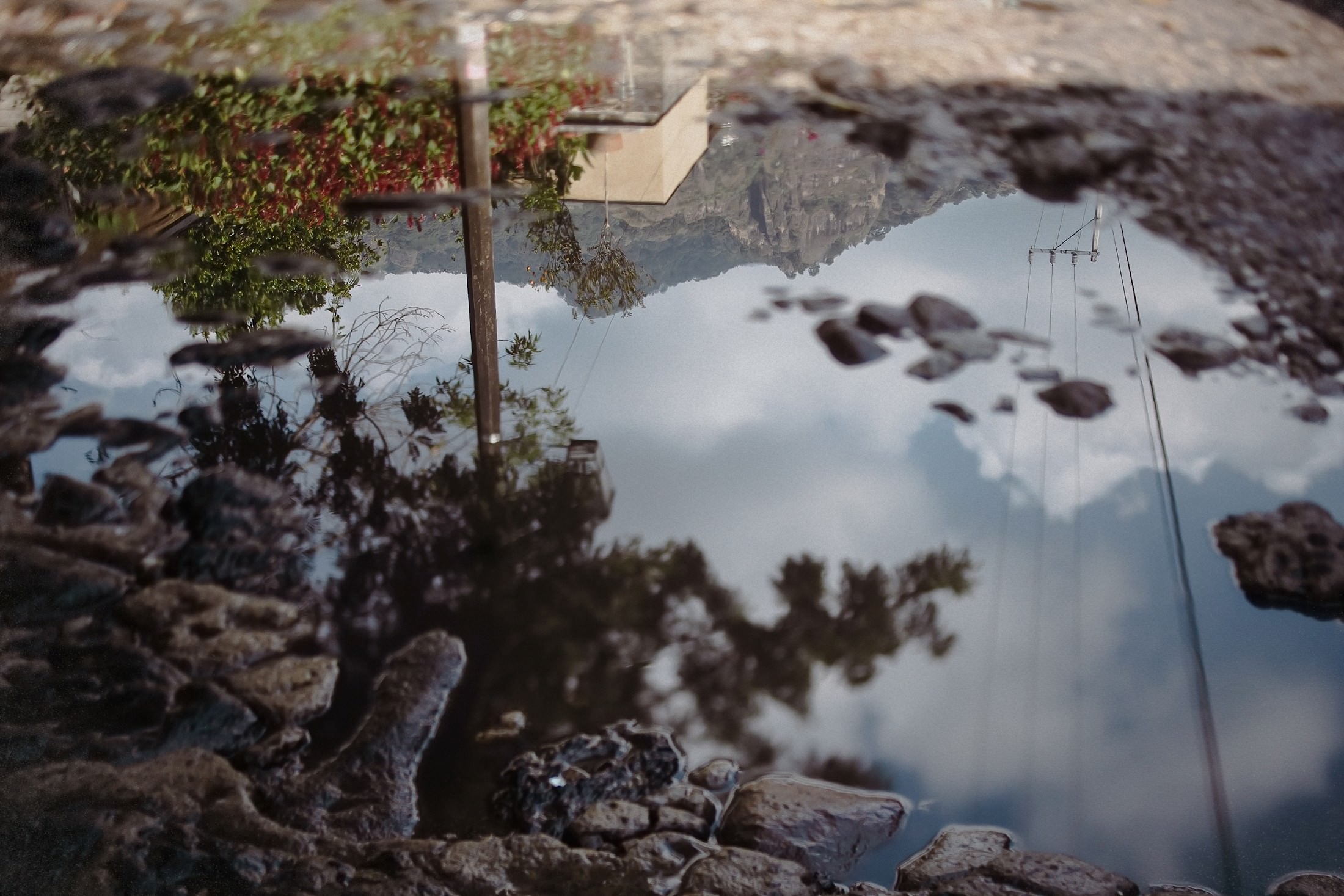 Eine Wasserfläche spiegelt die Landschaft mit ihrer markanten Felsformation kopfüber