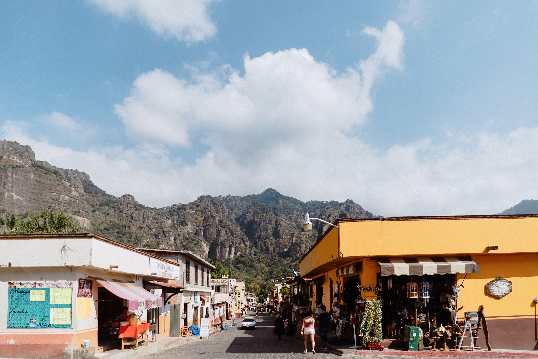 Der Marktplatz von Tepoztlán zeigt bunte Fassaden vor einer dramatischen Felsenkulisse