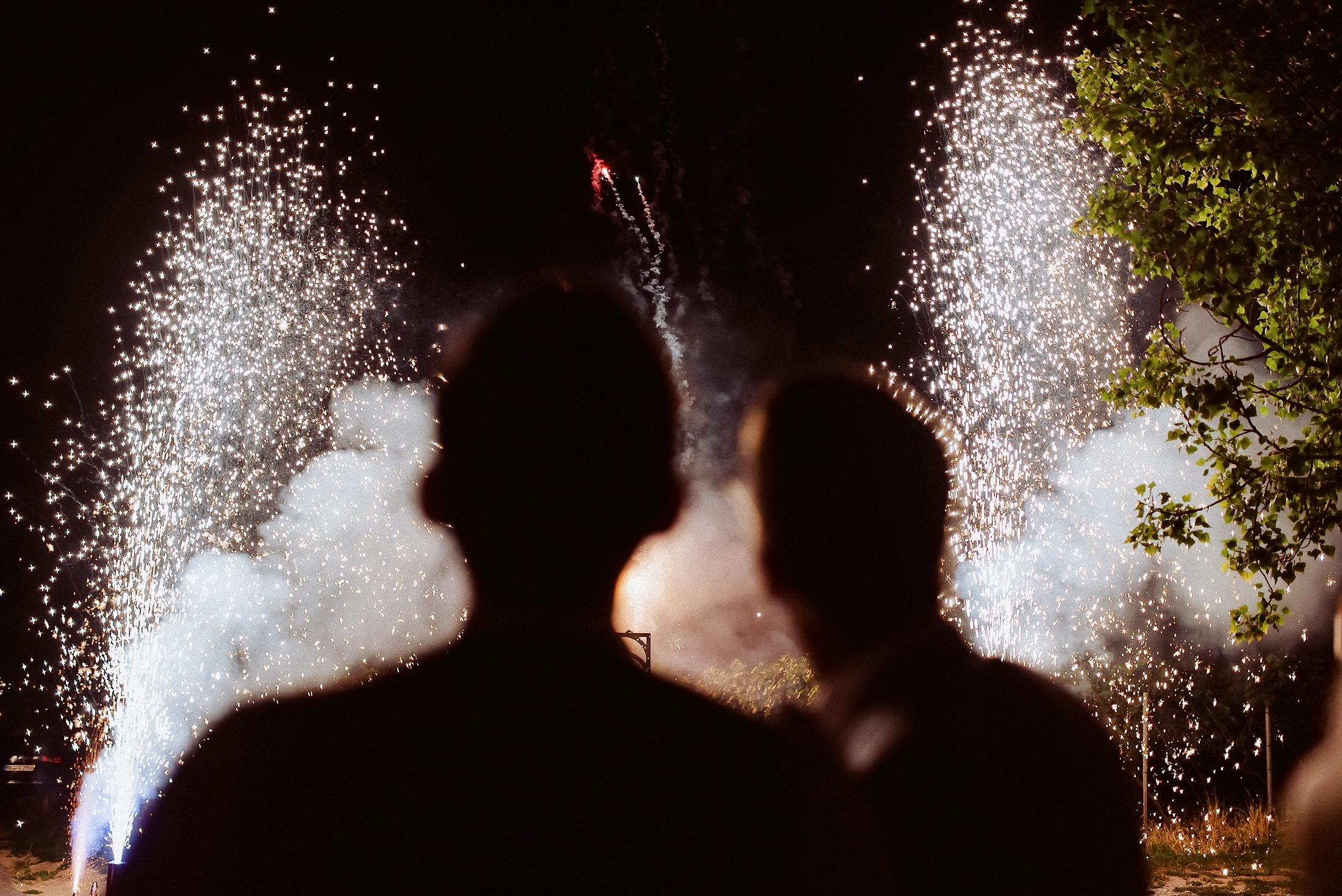 Das Hochzeitspaar beobachtet gemeinsam das Feuerwerk nachts.