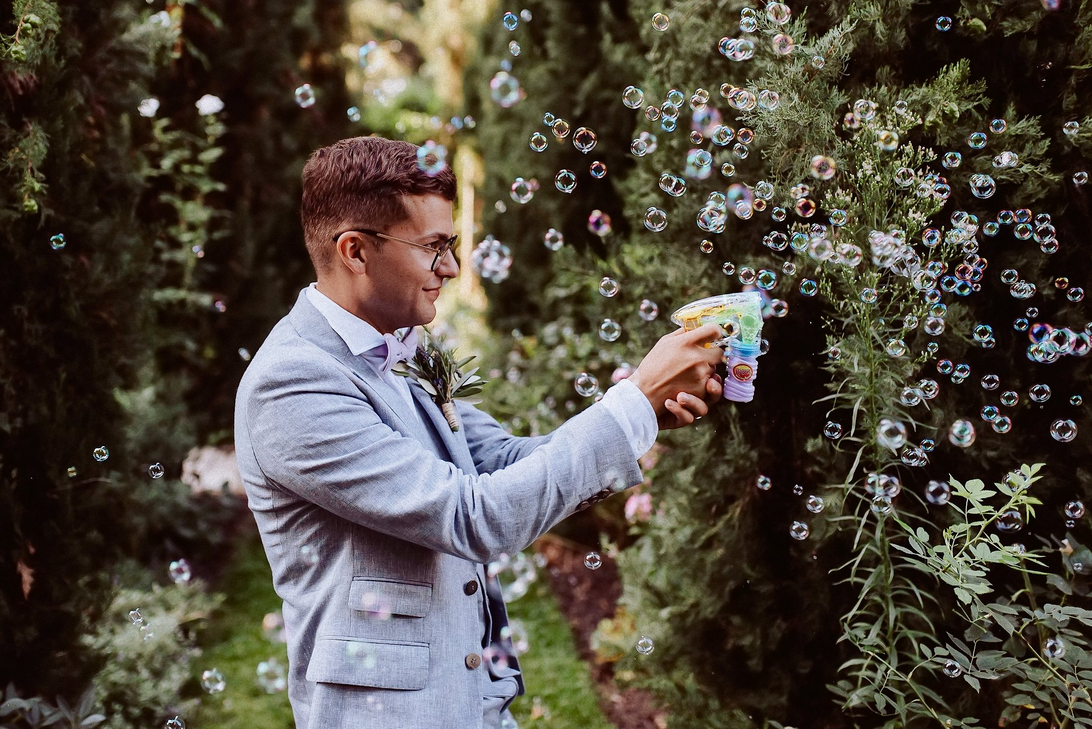 Seifenblasen-Wettkampf im Garten mit Gästen und Hochzeitspaar.