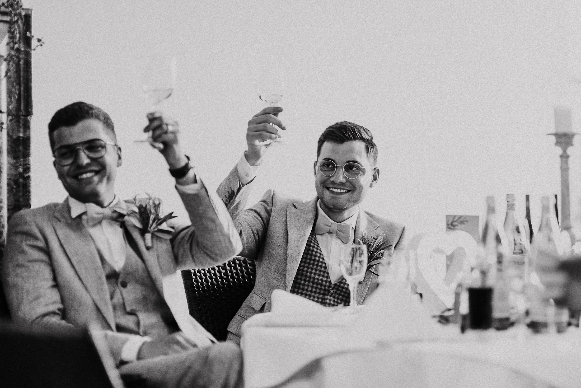 Das Hochzeitspaar stößt mit Wein an bei Tischdinner.