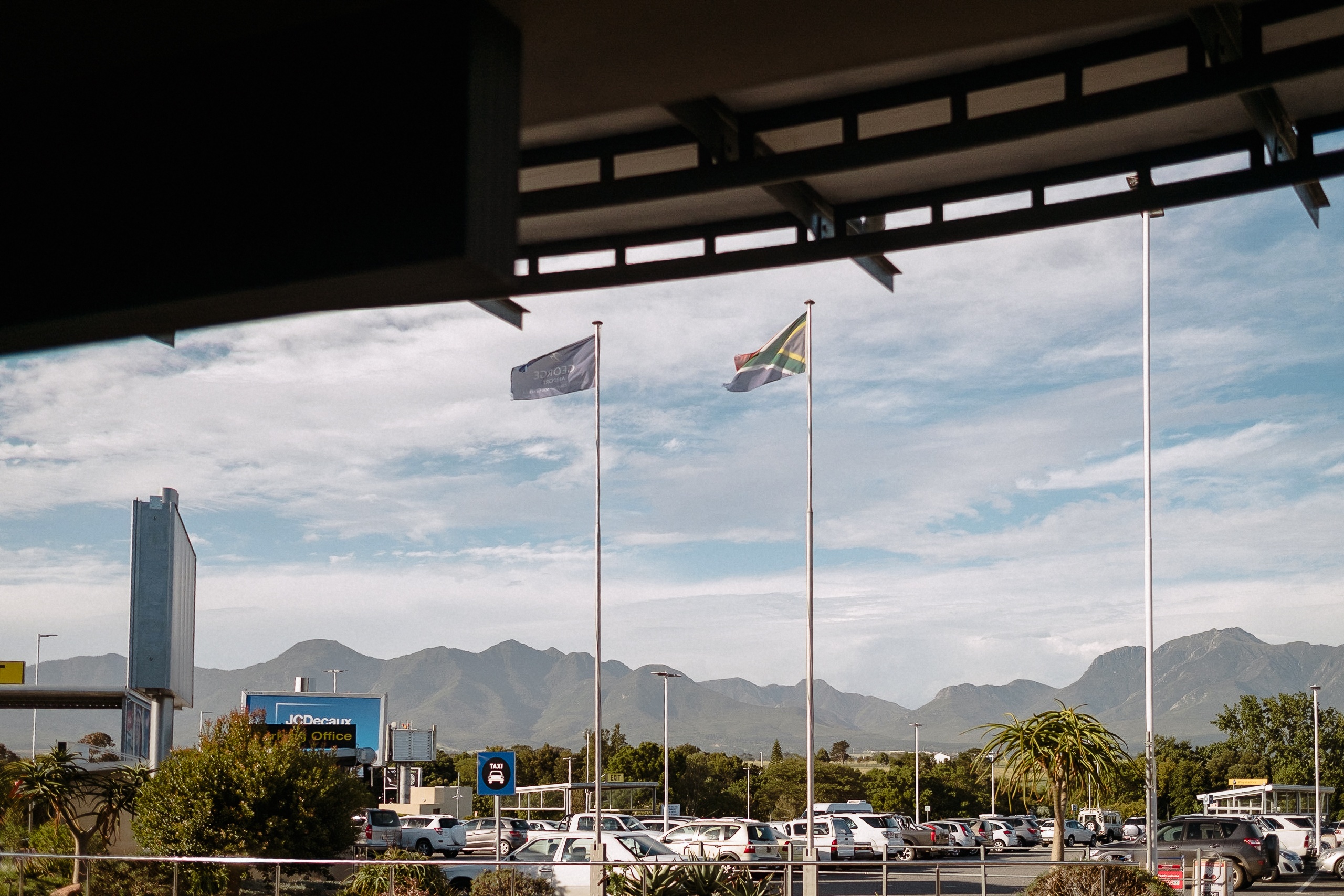 Südafrikanische Flagge und Flughafenfahne vor dem Terminal in George