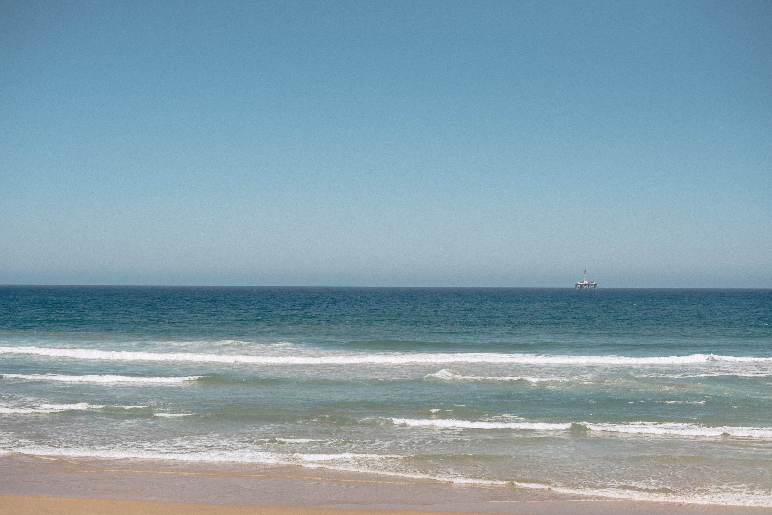 Brandung und Schiff am Horizont vor der Küste bei Mossel Bay