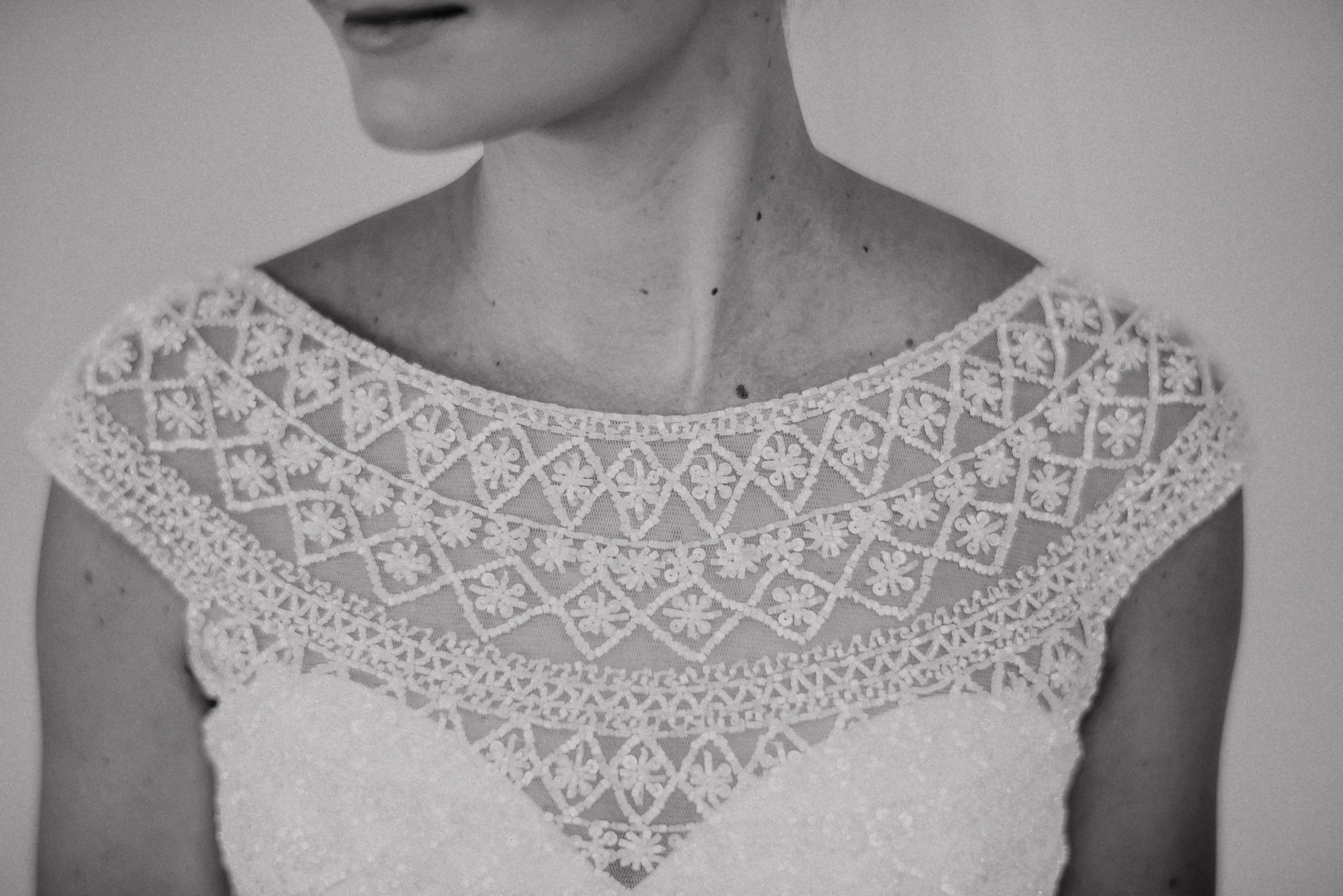 Schwarzweiß-Detail des Spitzenausschnitts am Brautkleid