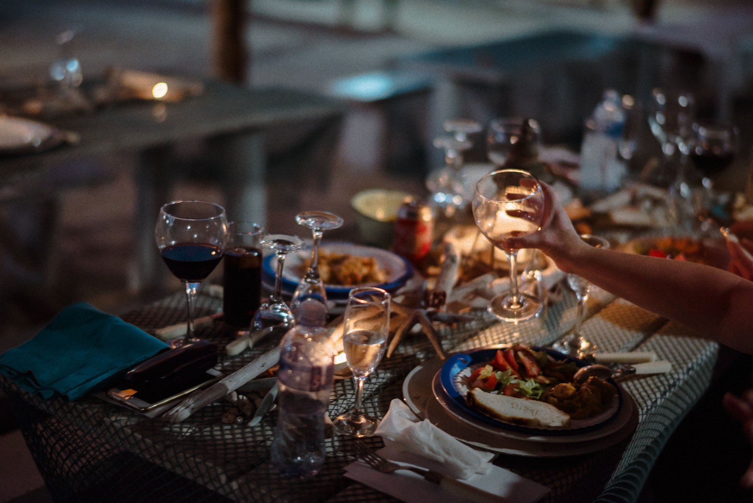 Der gedeckte Tisch mit Kerzen und Wein am Abend