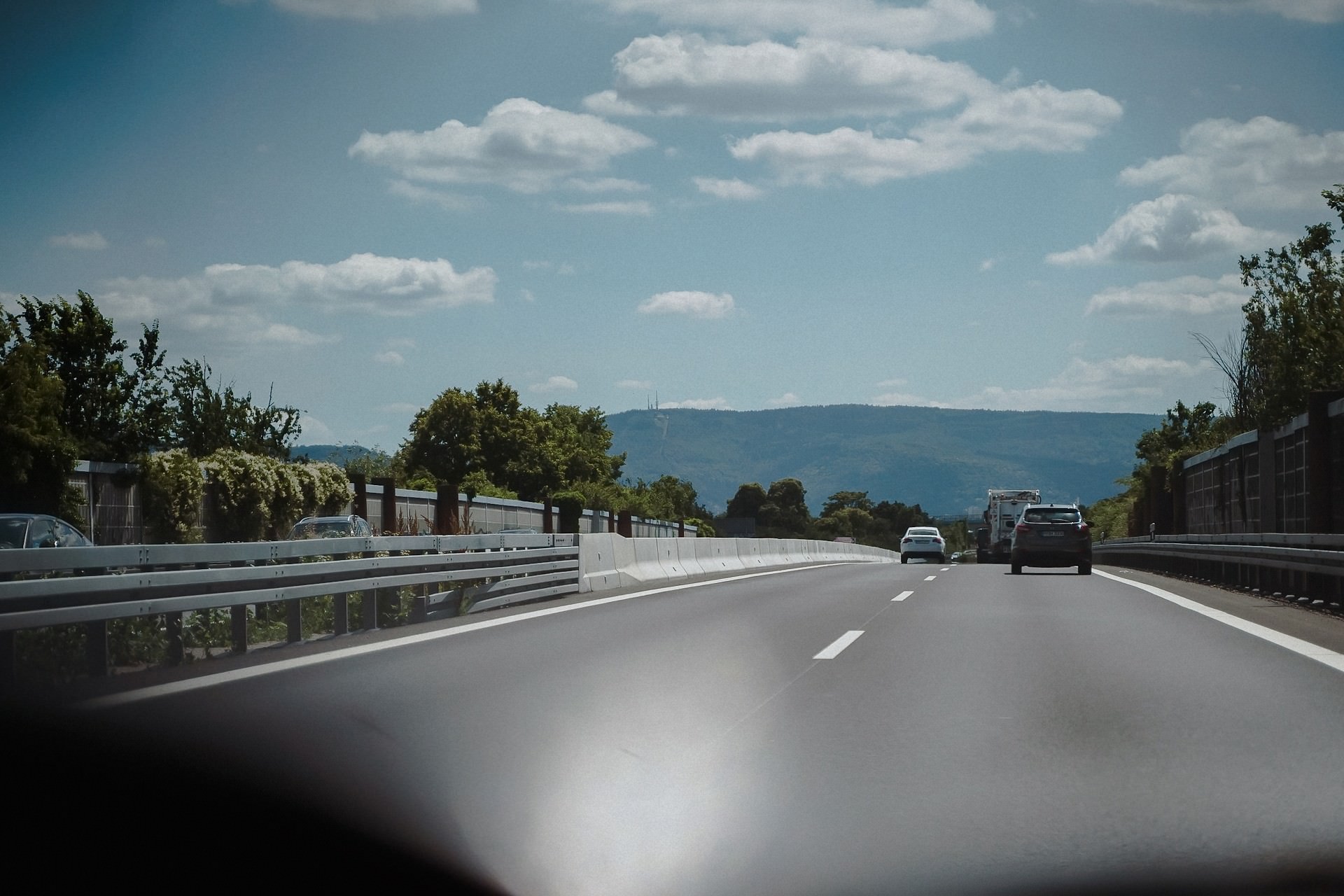Fahrt auf der Autobahn nach Heidelberg, Blick aus dem Fahrzeug auf die Berglandschaft.