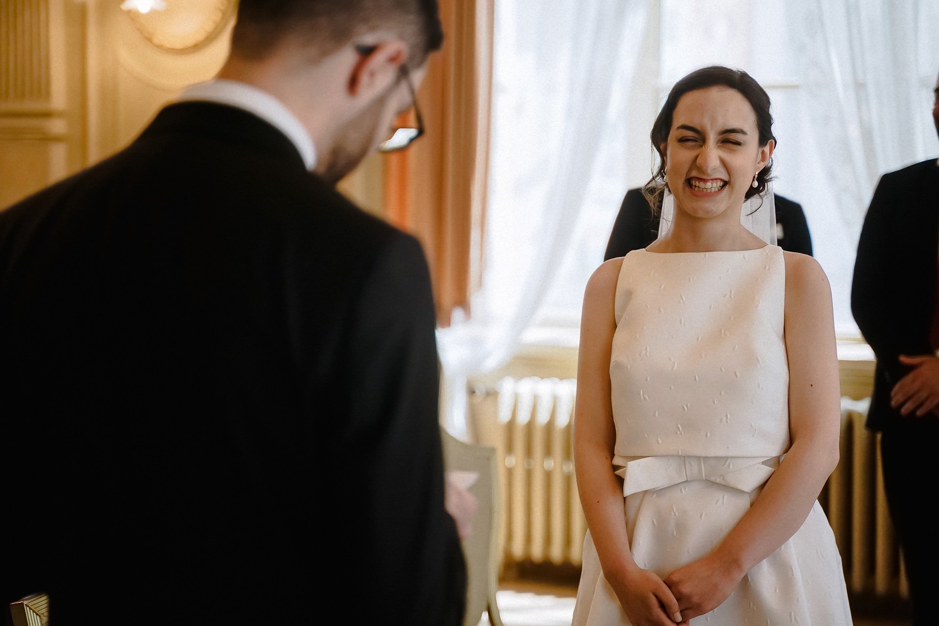 Braut strahlt freudig während des Eheversprechens im Trausaal.