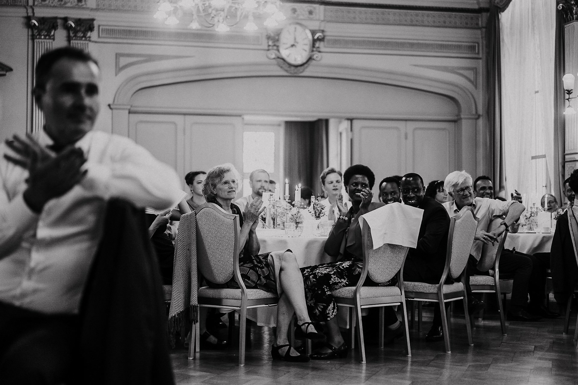 Hochzeitsgäste sitzen zusammen in einem emotionalen Moment im Festsaal.