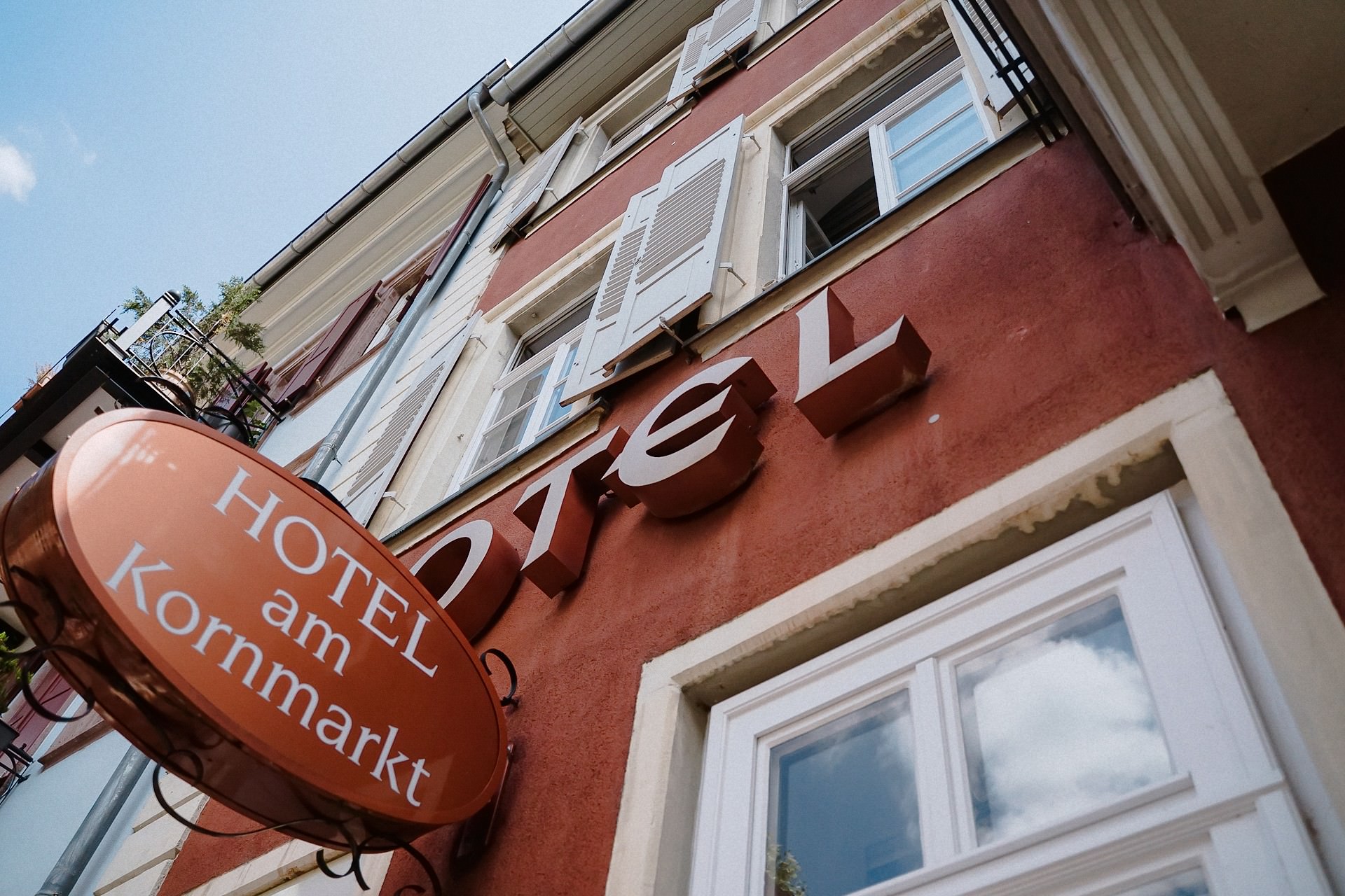 Hotel am Kornmarkt Schild an roter Gebäudefassade in der Altstadt.
