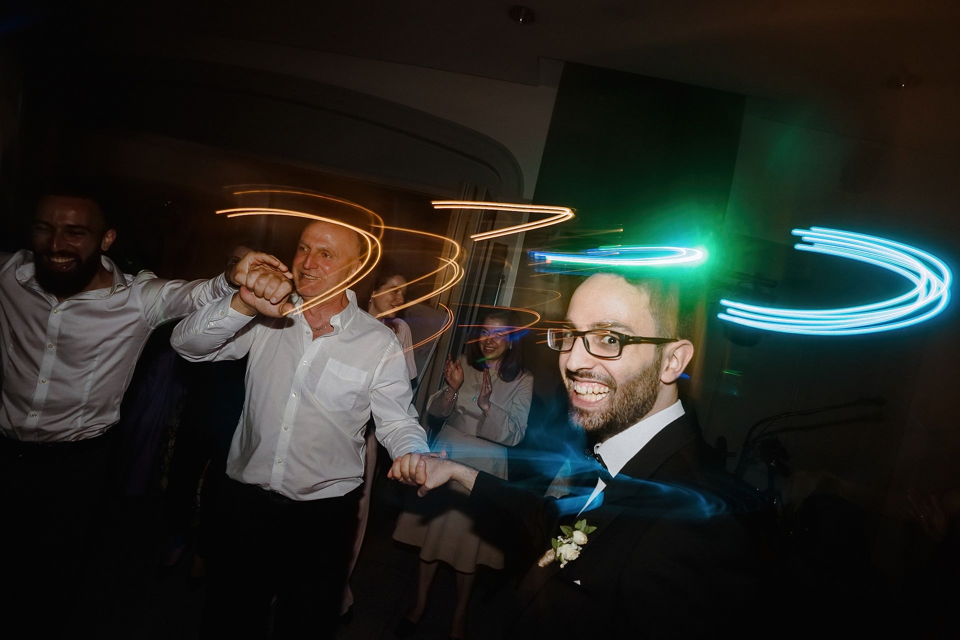 Hochzeitsgäste tanzen mit Langzeitbelichtung und Neon-Licht-Effekten.