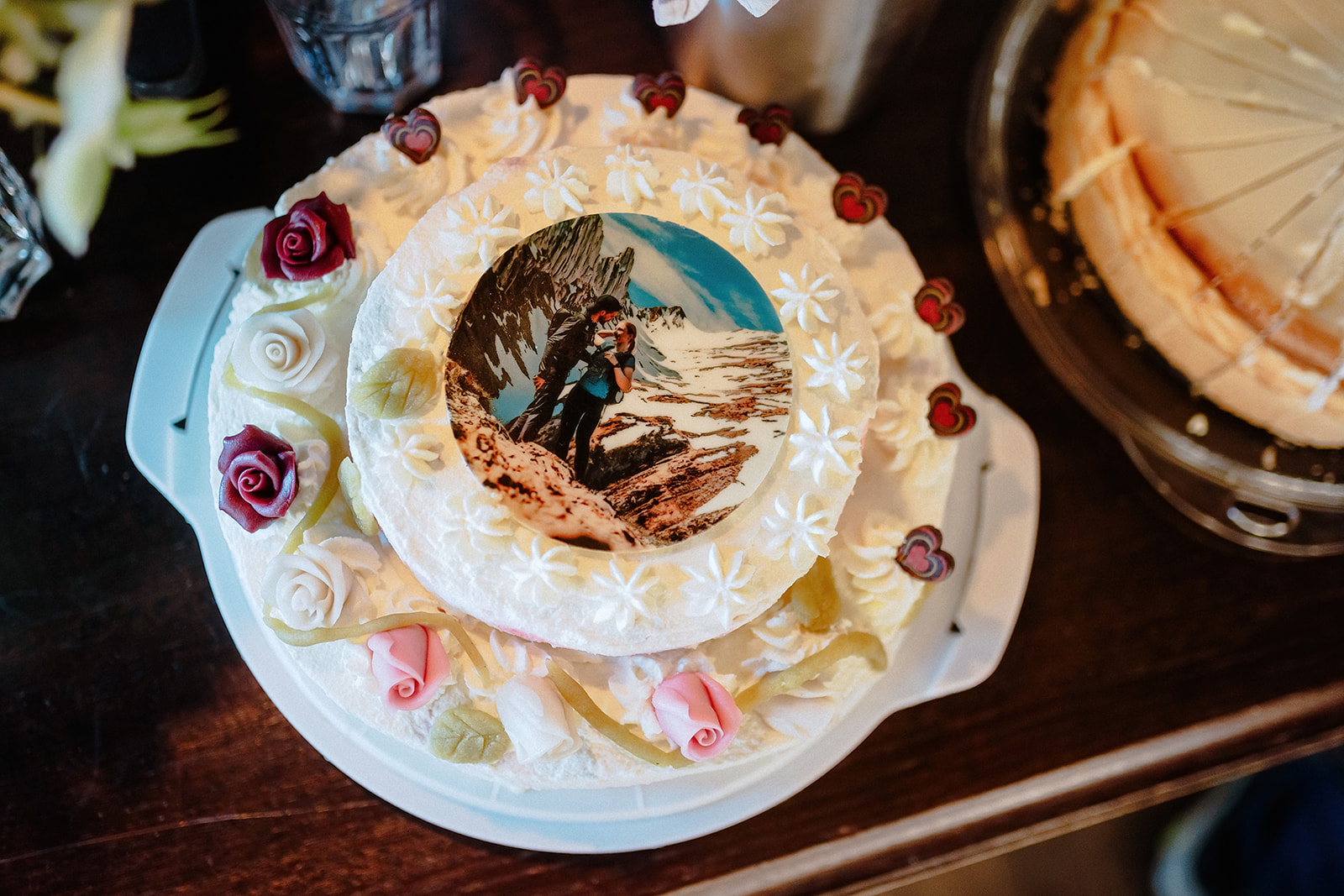 Hochzeitstorte mit Marzipanrosen und einem essbaren Foto des Paares obenauf
