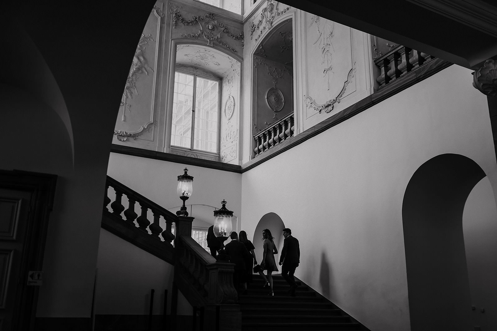 Gäste steigen das barocke Treppenhaus des Schlosses hinauf