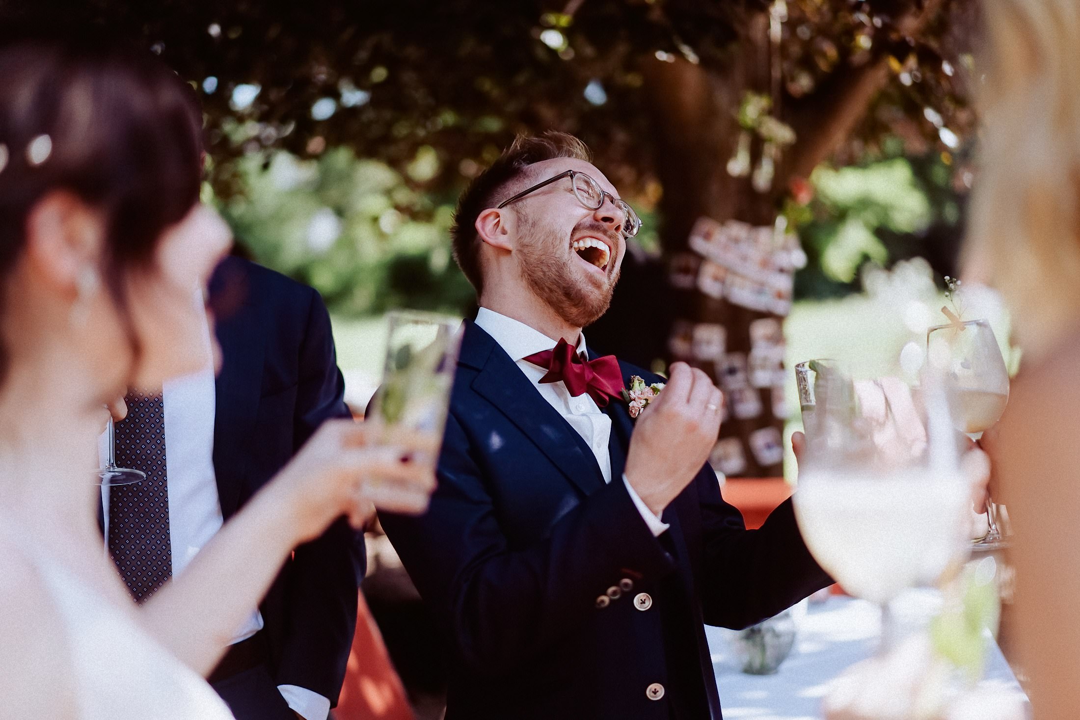 Bräutigam feiert mit Freunden bei Sekt, gute Laune im Garten.