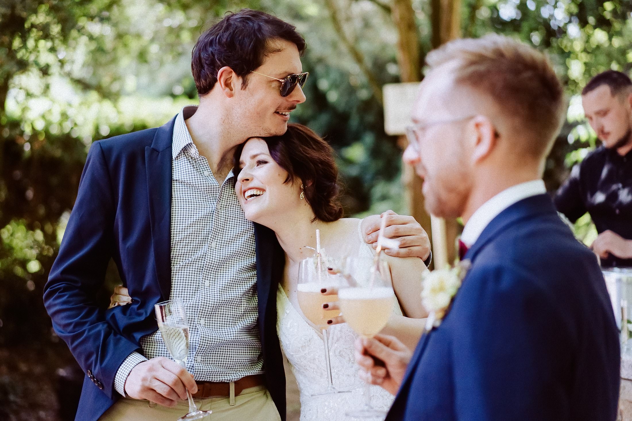 Hochzeitskuss des verliebten Brautpaares, sonniger Weingarten-Hintergrund.
