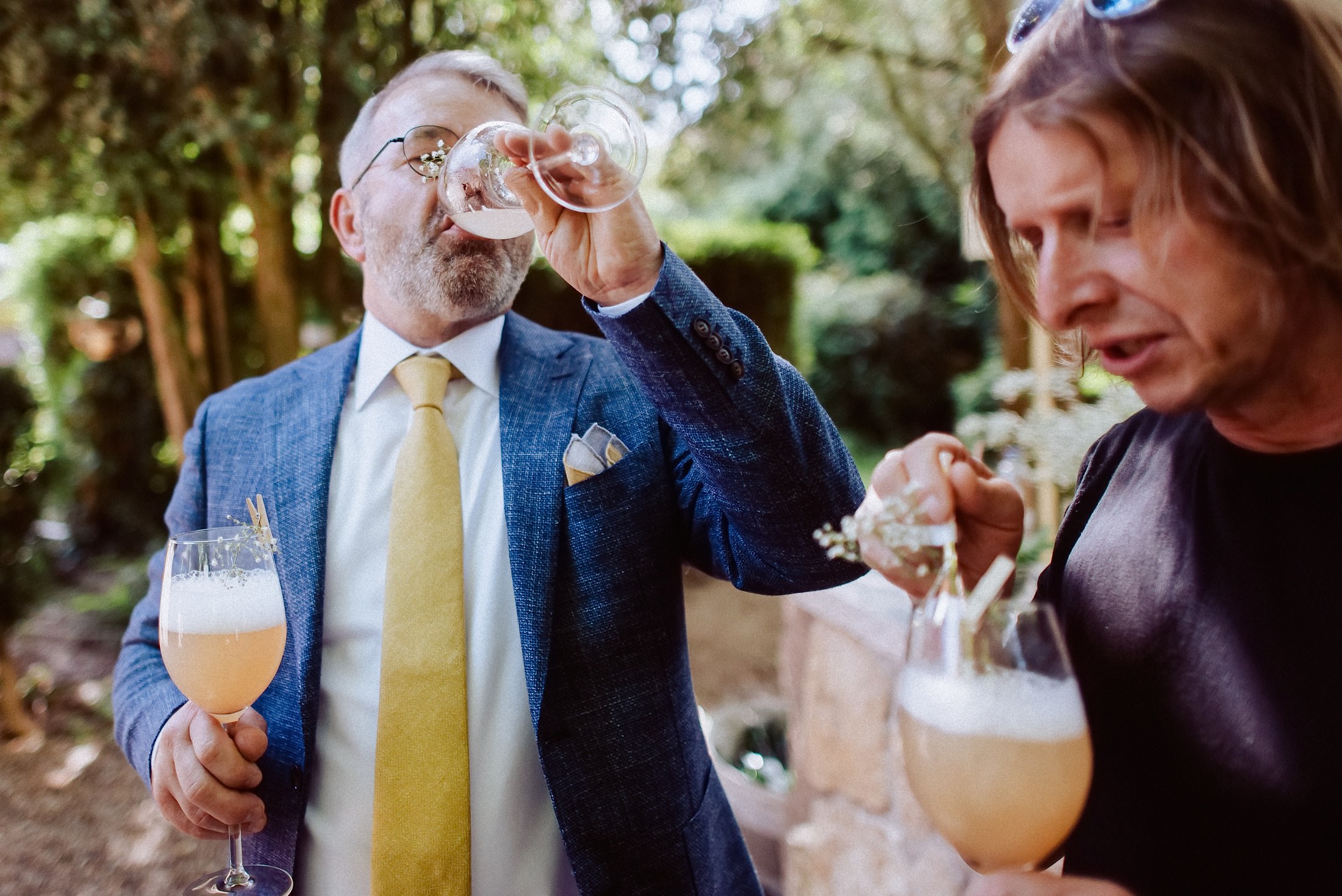 Freunde stoßen mit Champagner an, festlich dekorierter Festsaal.
