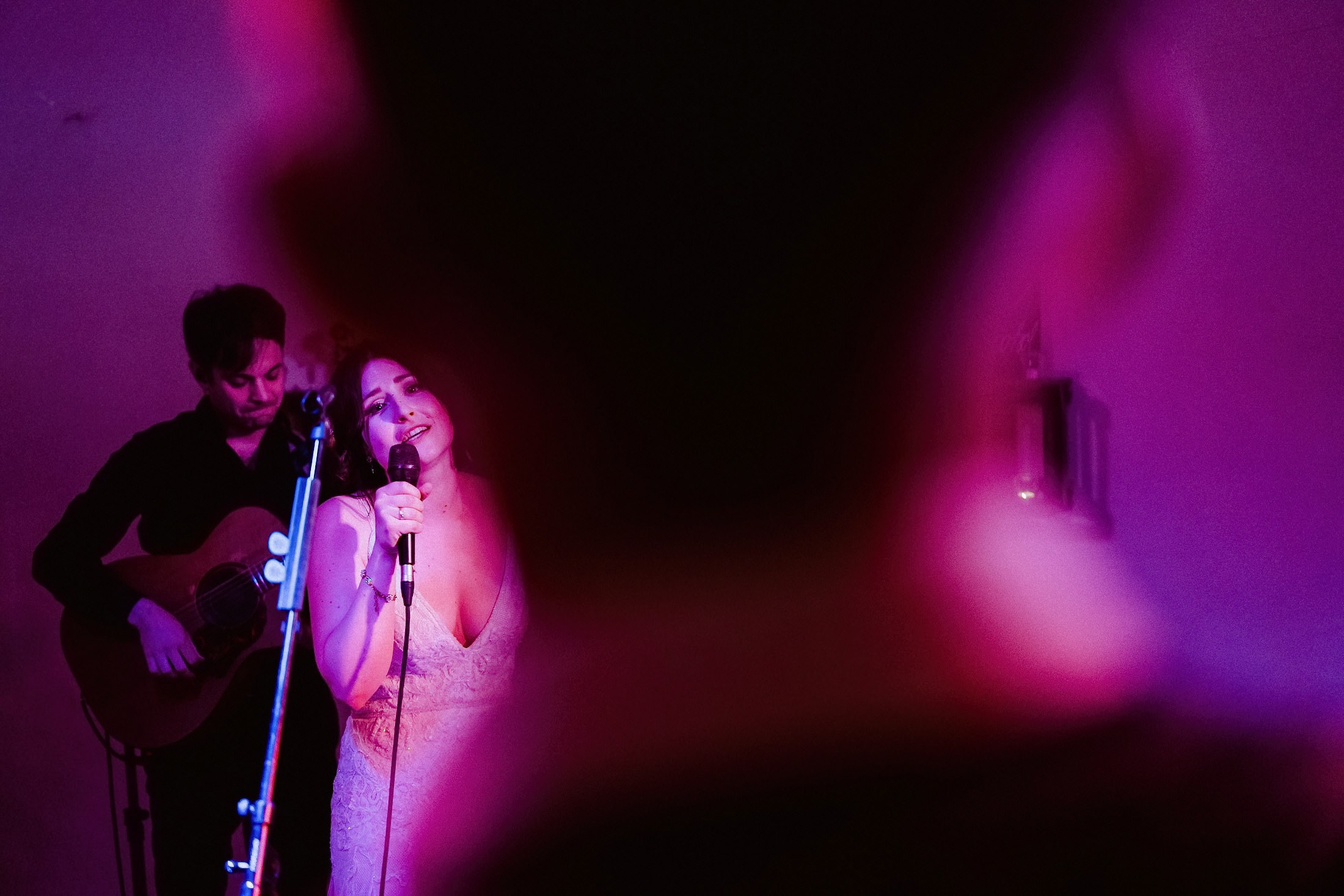 Gitarrist und Braut singen gemeinsam, Live-Musik im Festsaal mit stimmungsvollem Licht.