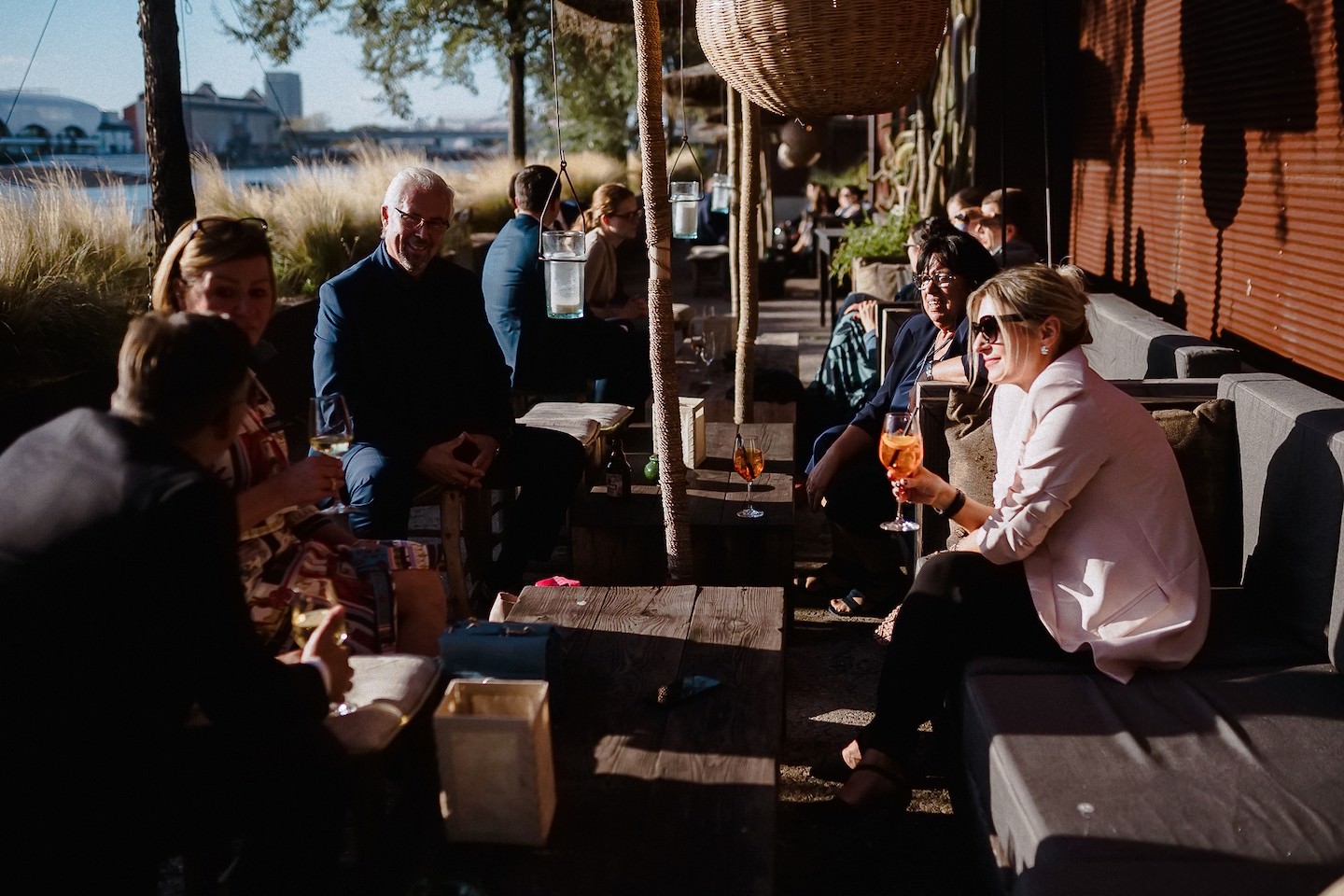 Gäste sitzen mit Aperol in der Abendsonne auf der Uferterrasse des Speicher 7