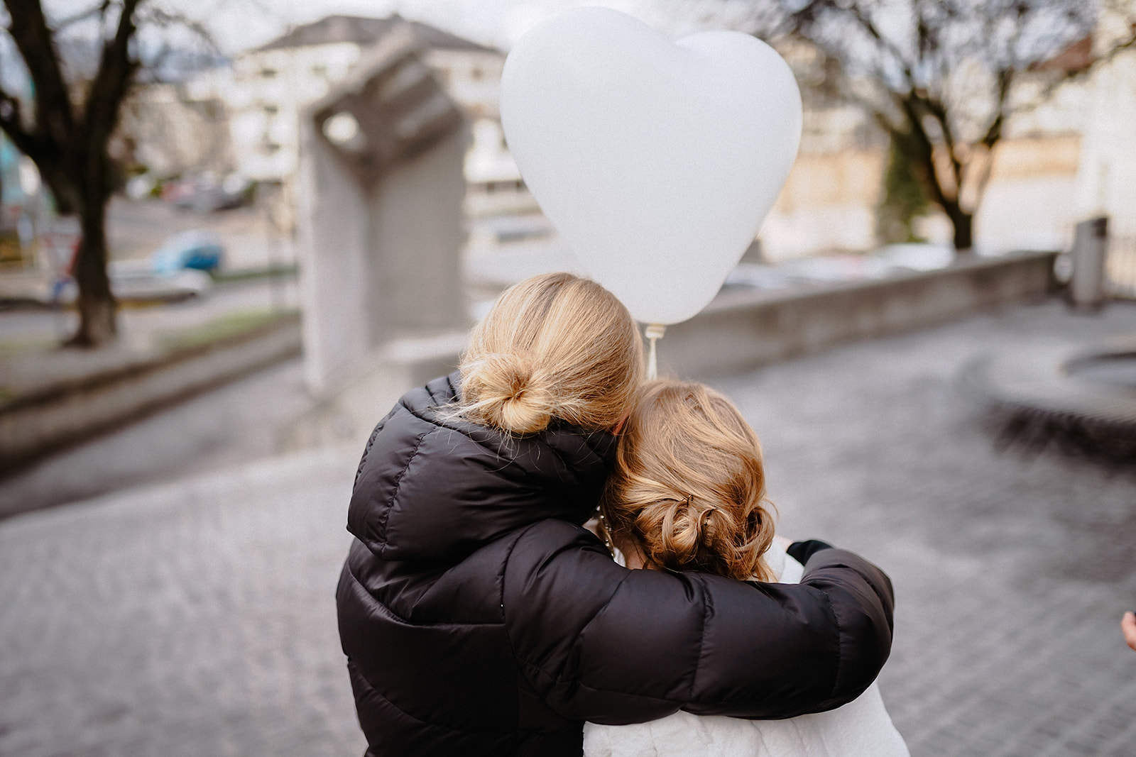 Zwei Gästinnen lehnen die Köpfe aneinander, darüber schwebt ein weißer Herzballon