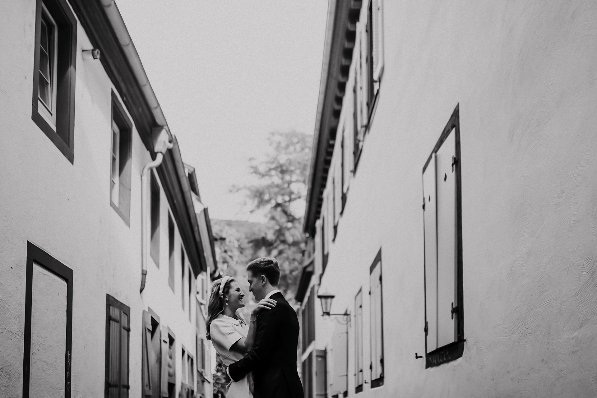 Brautpaar küsst sich vor roter Fassade in der Altstadt.