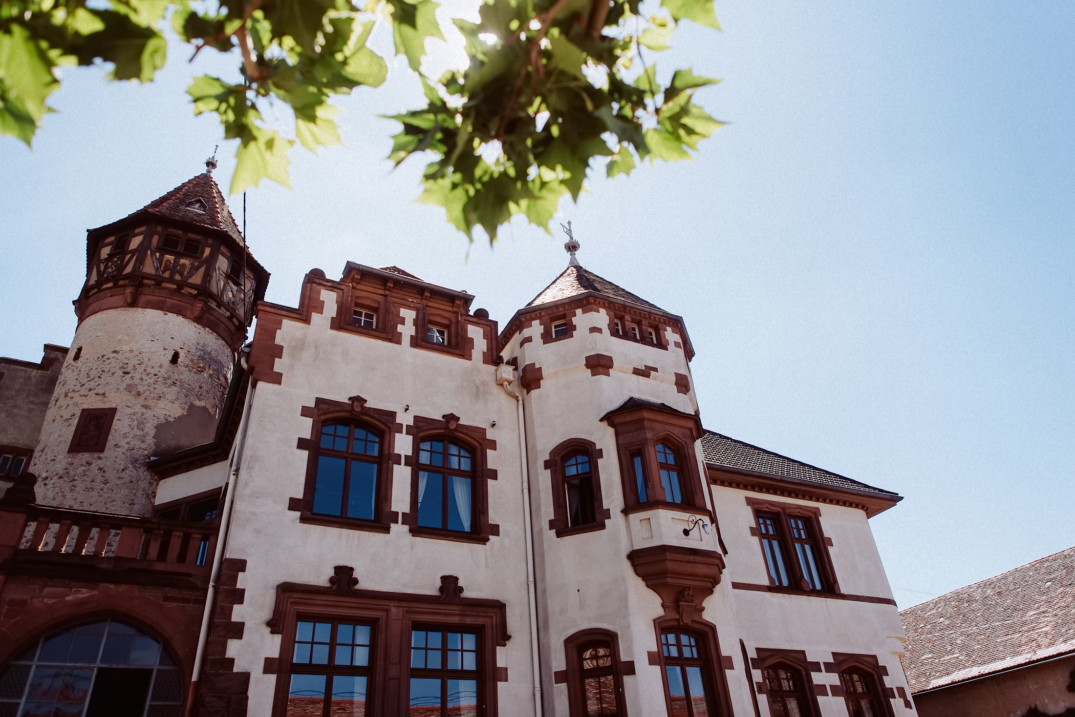 Fassade des Schlossgut Lüll mit Türmen an einem klaren Sommertag.